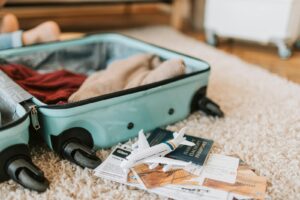 Gros plan d'une valise ouverte contenant des éléments essentiels de voyage comme un passeport et des billets, prête pour un voyage.